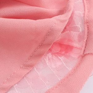 Gros plan sur le tissu à paillettes roses avec bordure en tulle et détails de couture