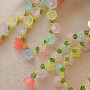 Detailed macro shot of matte floral beads and faceted crystal beads on silk fabric