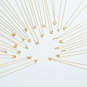 Minimalist gold letter necklace set with A-Z alphabet pendants on a white background