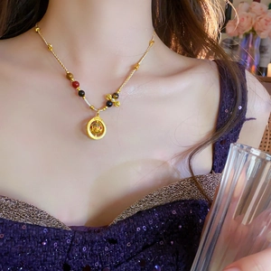Detail of elegant gold necklace with multi-colored beads and rotating circular pendant