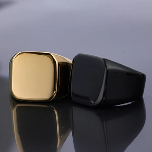 Macro detail of polished gold and black shield rings showing smooth metal surfaces