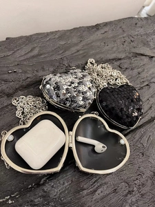Close-up of heart-shaped sequin mini bags showing interior storage for AirPods with chain