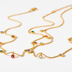 Elegant gold beaded necklace featuring colorful zircon charms on a clean white background