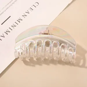 Detailed view of a holographic semi-circular hair claw clip on a soft beige background