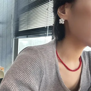 Primo piano di una collana in argento 925 e una collana di perle rosse vivaci