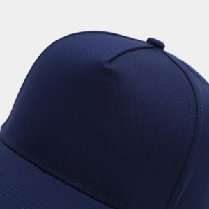 Détail macro d'une casquette trucker marine montrant les coutures et la texture du coton