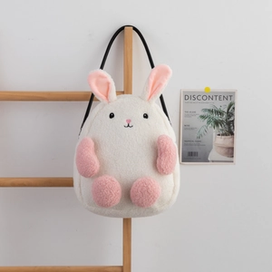 Cute white plush bunny shoulder bag with soft fur and pink embroidery details on wood rack