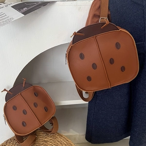 Retro ladybug children backpack in brown faux leather shown in a natural room setting