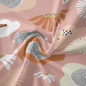 Close-up of pink Bohemian tapestry fabric with orange floral prints and soft textile texture