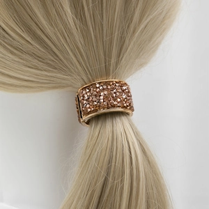 Elegant gold ponytail cuff with amber crystals shown on blonde hair against white background