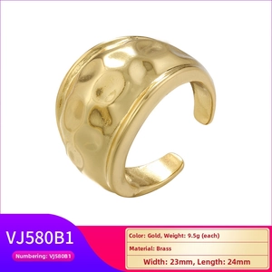 Detail view of gold brass ring with hammered texture showing 23mm width and 9.5g weight