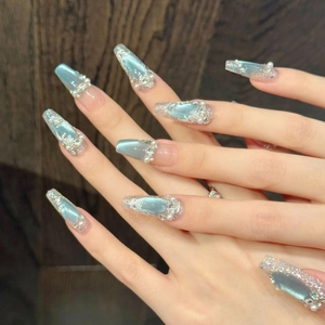 Unghie finte occhio di gatto blu con perle e cristalli in forma coffin su mano