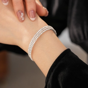 Detailed close-up of a three-row sparkling rhinestone stretch bracelet worn on a wrist