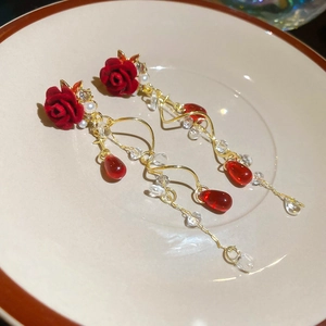 Detail of vintage red flocked flower earrings with gold tassels and white pearls
