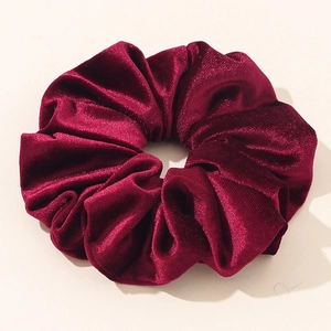 Detailed view of large burgundy velvet scrunchie with soft texture and glossy finish