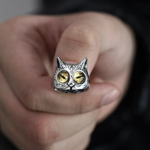 Close-up of vintage owl ring with vibrant yellow eyes worn on a finger