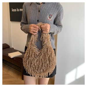 Detailed close-up of a khaki faux fur handbag with a soft, plush texture and fringe design