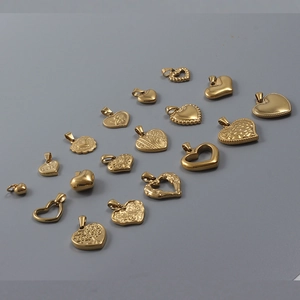 Polished 18k gold heart-shaped pendants in various styles on a neutral background