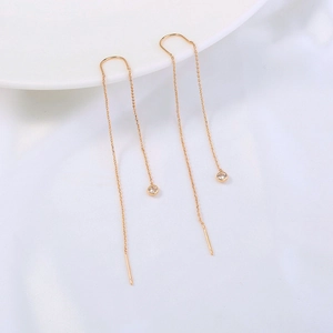 Macro shot of gold tassel ear threads featuring delicate round clear cubic zirconia gems