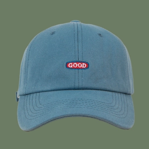 Detail of blue cotton baseball cap with red and white GOOD embroidery on the front