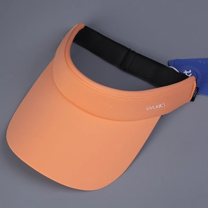 Close-up of orange sports visor with UVLABCL logo and elastic strap on grey background