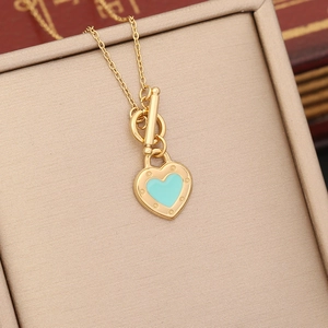 Gold stainless steel heart necklace with blue enamel pendant in a beige jewelry box