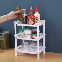 Three-tier white plastic kitchen spice rack storage organizer on wooden surface