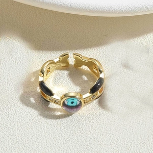 Macro shot of gold open ring with evil eye enamel pattern and side crystal accents