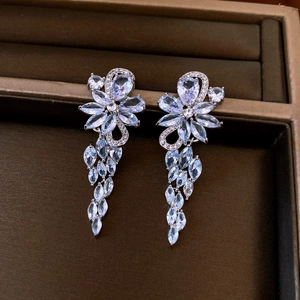 Macro shot of silver vintage flower drop earrings with blue and clear zircon details