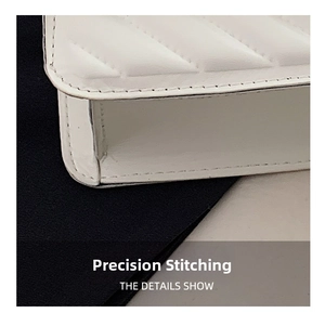 Detail of precise stitching and V-shaped quilted leather texture on white crossbody bag