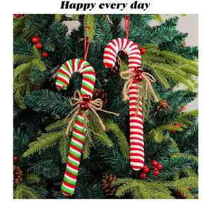 Detail of red and white striped candy cane ornaments with bells on a Christmas tree