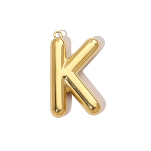 Détail macro du pendentif lettre K dorée style ballon 3D avec finition polie brillante