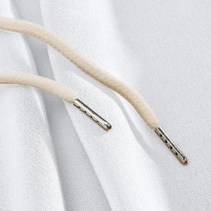 Detail of knit fabric texture with beige drawstring and metallic cylinder tips