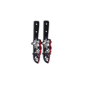 Detail of acrylic Halloween knife charms with white flower pattern and red blood splatters
