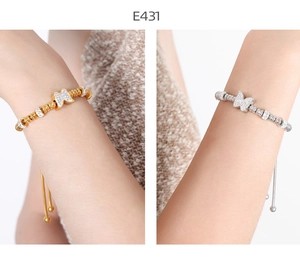 Detail of adjustable beaded bracelets with crystal butterfly charms in gold and silver