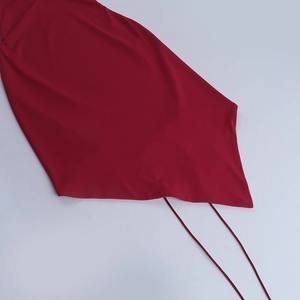 Detail of dark red halter neck top featuring smooth fabric and long adjustable tie straps