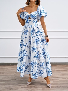 Dettaglio vestito bohémien bianco con fiori blu e ritagli eleganti in vita sottile