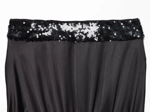 Close-up of sparkling black sequins on smooth satin fabric of a strapless top