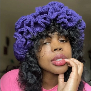 Macro detail of purple crochet knit hat showing bold ruffle edge and chunky yarn texture