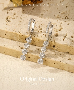 Macro shot of S925 sterling silver long tassel earrings with sparkling floral diamond studs