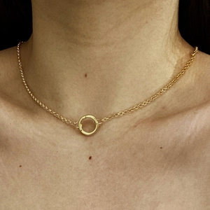 Close-up of 18K gold plated necklace with circular pendant worn by a model