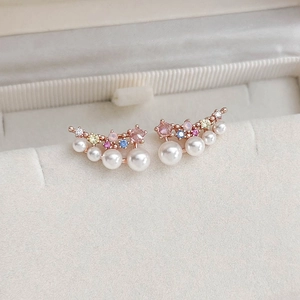 Detailed macro view of zircon flower butterfly earrings with pearls and crystals