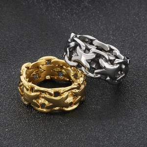 Macro view of gold and silver X-shaped hollow chain rings on a textured black background