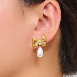 Golden butterfly earrings with teardrop pearls shown on a model for a stylish look
