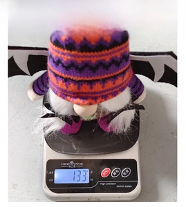 Weight measurement of Halloween gnome plush toy with bat wings on a digital scale 133g