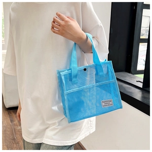 Detail of bright blue mesh tote bag showing snap closure and Fashion bag woven label