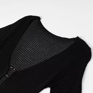 Close-up of black hollow knit cardigan featuring elegant metal ring buckle details