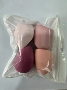 Set of four colorful makeup sponges in pink and orange tones inside a clear poly bag