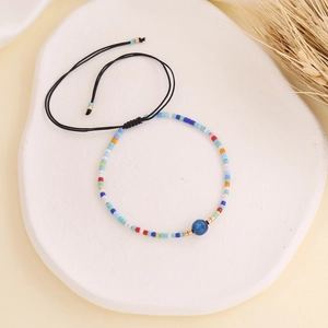 Close-up of Bohemian beaded bracelet with a blue center stone and adjustable woven rope