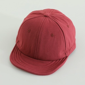 Detailed top view of a dark red short brim baseball cap showing six-panel stitching